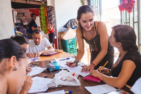 A woman teaches a class of adult students.